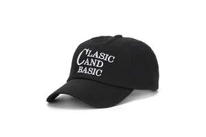 Détail de la broderie de lettres blanches sur une casquette de baseball noire en coton