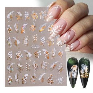 Detailed view of white and gold leaf nail stickers with floral patterns on natural nails