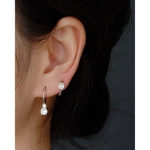Close-up of minimalist s925 silver hoop earrings with oval zircon pendant on a model