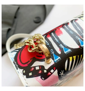 Close-up of golden hardware connectors and fine stitching on the graffiti chain bag