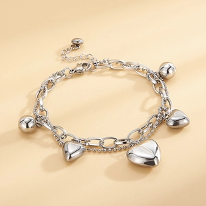 Close-up of a double-layer silver steel bracelet with heart and bead charms