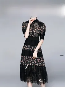 Detail of black lace polka dot dress featuring a high collar and sheer short sleeves