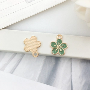 Detailed close-up of cherry blossom enamel pendant with green oil and golden finish