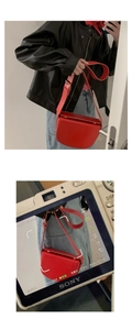 Macro view of vintage red PU leather saddle bag with gold buckle and adjustable strap