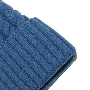 Detailed macro view of deep blue ribbed knit texture and folded cuff on a warm beanie