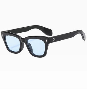 Detail of cat eye sunglasses with light blue lenses and star rivets on black frames