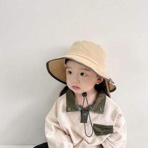 Detailed view of baby bucket hat with neck protection flap and green piping trim