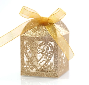 Vue détaillée de la boîte à bonbons dorée à paillettes avec motif cœur et ruban