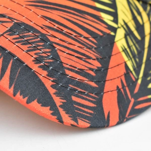 Detail of tropical palm leaf print on woven fabric with neat five-row brim stitching