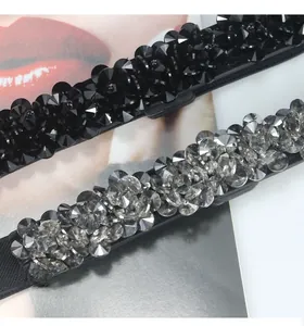 Detail showing two floral crystal beaded elastic belts in black and grey for dresses