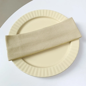 Close-up of beige ribbed knit headband on a decorative plate with soft natural light