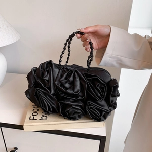 Elegant black silk evening bag featuring 3D satin roses and a pearl beaded handle