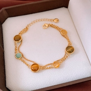 Detail of 18k gold plated S925 silver bracelet featuring round cat eye stone inlays