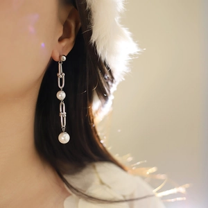 Détail de boucles d'oreilles à maillons fer à cheval et perles en acier inoxydable