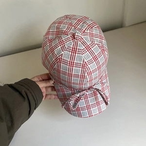 Gros plan sur une casquette en coton à carreaux rouges avec un nœud décoratif élégant