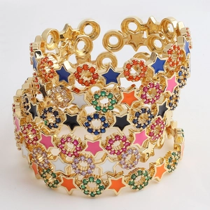 Detail of gold open bracelets with colorful enamel stars and sparkling cubic zirconia