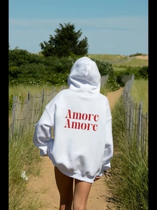 Oversized λευκό φούτερ με κόκκινο τύπωμα AMORE στην πλάτη για casual streetwear εμφάνιση