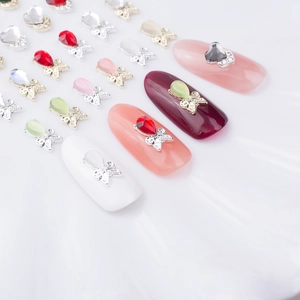 Macro detail of alloy bowknot nail charms with opal stones on colorful fake nails