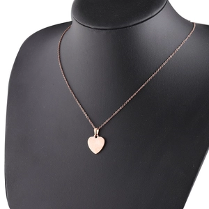 Detail of rose gold heart pendant necklace displayed on a black neck bust model