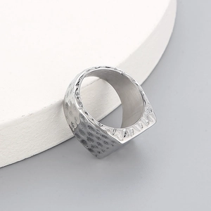 Detailed close-up of silver hammered texture on a square wide punk titanium steel ring