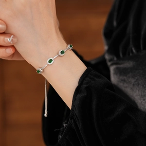 Detailansicht des verstellbaren Armbands mit grünen Edelsteinen auf schwarzem Samt
