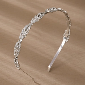 Detailed close-up of sparkling rhinestone leaf patterns on an elegant silver bridal headband