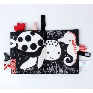 Detail of soft black and white baby cloth book showing turtle and seahorse patterns