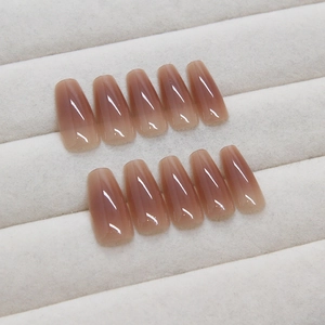 Glossy nude brown gradient press-on nails in trapezoid shape on white velvet display