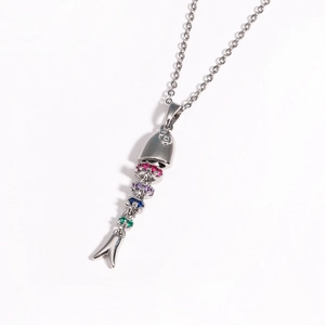 Close-up of a silver fishbone pendant with colorful gemstones and movable joints