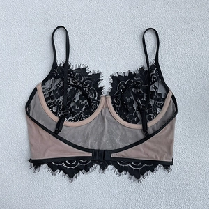 Détail du soutien-gorge en maille chair avec dentelle de cils noire et fines bretelles