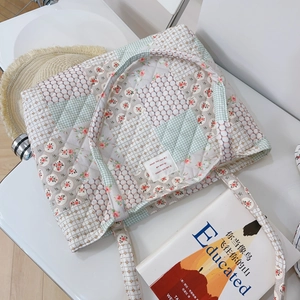 Gros plan détaillé d'un sac cabas en coton matelassé aux motifs fleuris patchwork