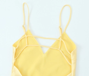 Détail d'une robe en satin jaune vif avec des bretelles croisées au dos et un tissu fluide