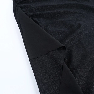 Close-up of black glitter fabric with elegant draping and textured shimmer finish