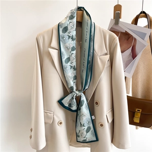 Detail of floral silk twilly scarf tied on a suit blazer neck with vintage flower patterns