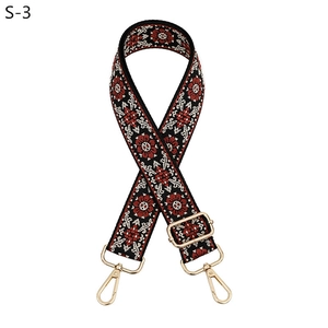 Detail of ethnic floral embroidery on adjustable strap with gold metal lobster clasps