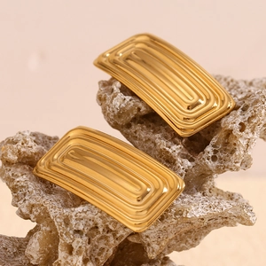 Detailed macro view of 18K gold plated rectangular earrings with textured geometric patterns
