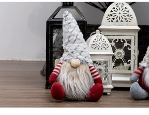 Close-up of a Christmas gnome doll with a grey hat and white beard on a wooden floor