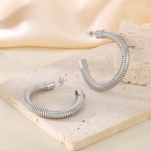 Dettaglio orecchini a perno a forma di C in argento con trama a spirale metallica