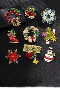 Detail view of 9 Christmas brooches with enamel finish and colorful rhinestones