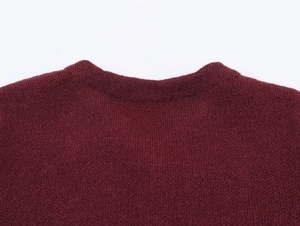 Détail du col d'un pull en maille bordeaux montrant la texture fine du tissu