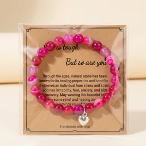 Pink zebra stone bead bracelet with silver heart charm on card in packaging