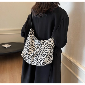 Detailed view of the leopard print canvas tote bag on a model in a minimalist setting