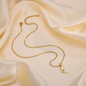 Close-up of golden tulip pendant with teardrop zircon on elegant champagne silk