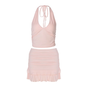 Flat lay of pink halter neck top and tiered ruffle mini skirt set on white background