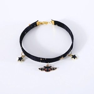 Detail of velvet pet choker featuring gold bat and star pendants with adjustable chain