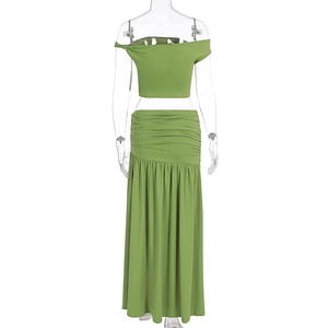 Detail of green two-piece set with pleated skirt and strapless crop top showing fabric texture