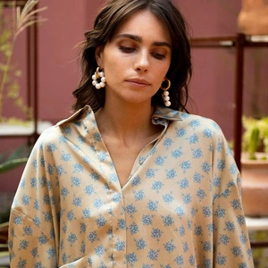 Elegant gold hoop earrings with white pearls paired with a blue floral printed blouse