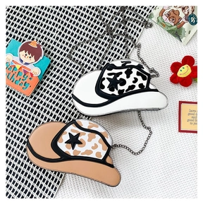 Detail view of denim hat shaped crossbody bags with star patch and chain straps
