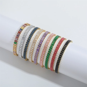 Minimalist gold bracelets set with colorful rectangular zircons on white display