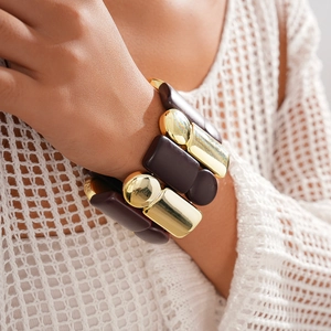 Macro shot of chunky gold metal and purple resin block geometric stretch bracelet